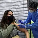 Un sanitario vacuna a una mujer contra la Covid-19