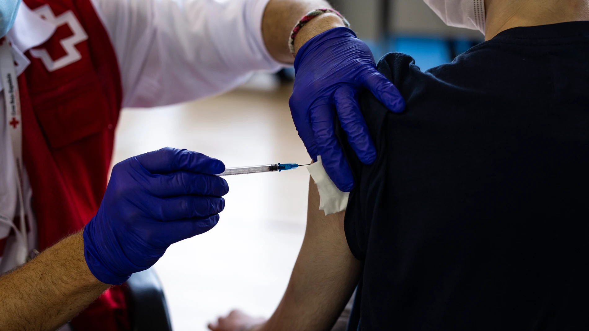 Un voluntario de Cruz Roja administra una dosis de la vacuna contra el Covid-19 a un estudiante universitario en el campus de Ciudad Universitaria, a 14 de septiembre de 2021, en Madrid, España