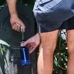 Una persona rellena una botella de agua en una fuente en Madrid