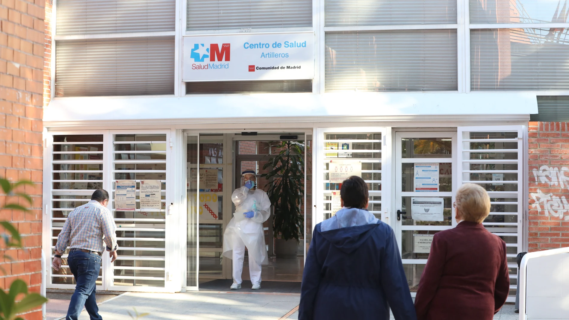 Una sanitaria sale a atender a las numerosas personas que hacen cola en el Centro de Salud Vicálvaro-Artilleros en el distrito de Vicálvaro, en Madrid