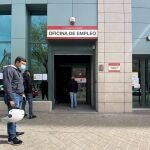 Varias personas esperan en las inmediaciones de una oficina de empleo en Madrid