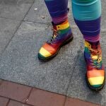 Vista del calzado de un asistente a la celebración del Orgullo con la bandera del arcoiris