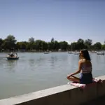 Una mujer toma el sol en el parque de El Retiro de Madrid