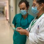 Dos profesionales sanitarios consultan un teléfono móvil en un centro de Andalucía