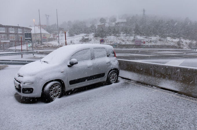Un coche cubierto de nieve en el Puerto de Navacerrada