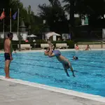 Un hombre se tira de cabeza al agua en una piscina municipal de Madrid