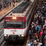 Un gran número de pasajeros espera la llegada de un tren en la estación de Madrid Puerta de Atocha