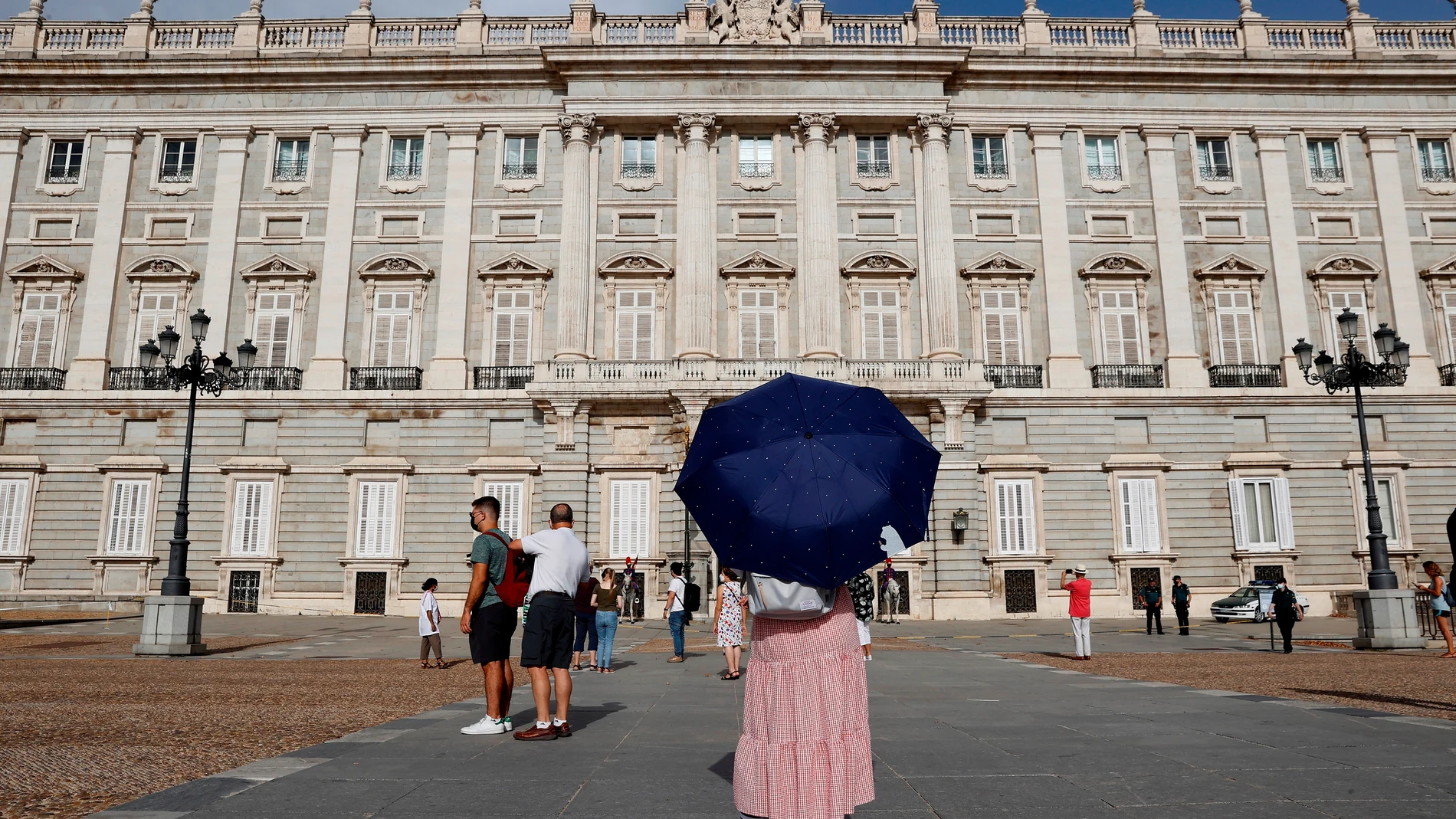 Una turista evita el sol con un paraguas en Madrid, este pasado sábado, ante el Palacio Real de Madrid