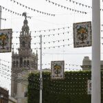 Vista de calles del centro de Sevilla, con la Giralda al fondo, engalanadas con adornos por la Feria de Abril