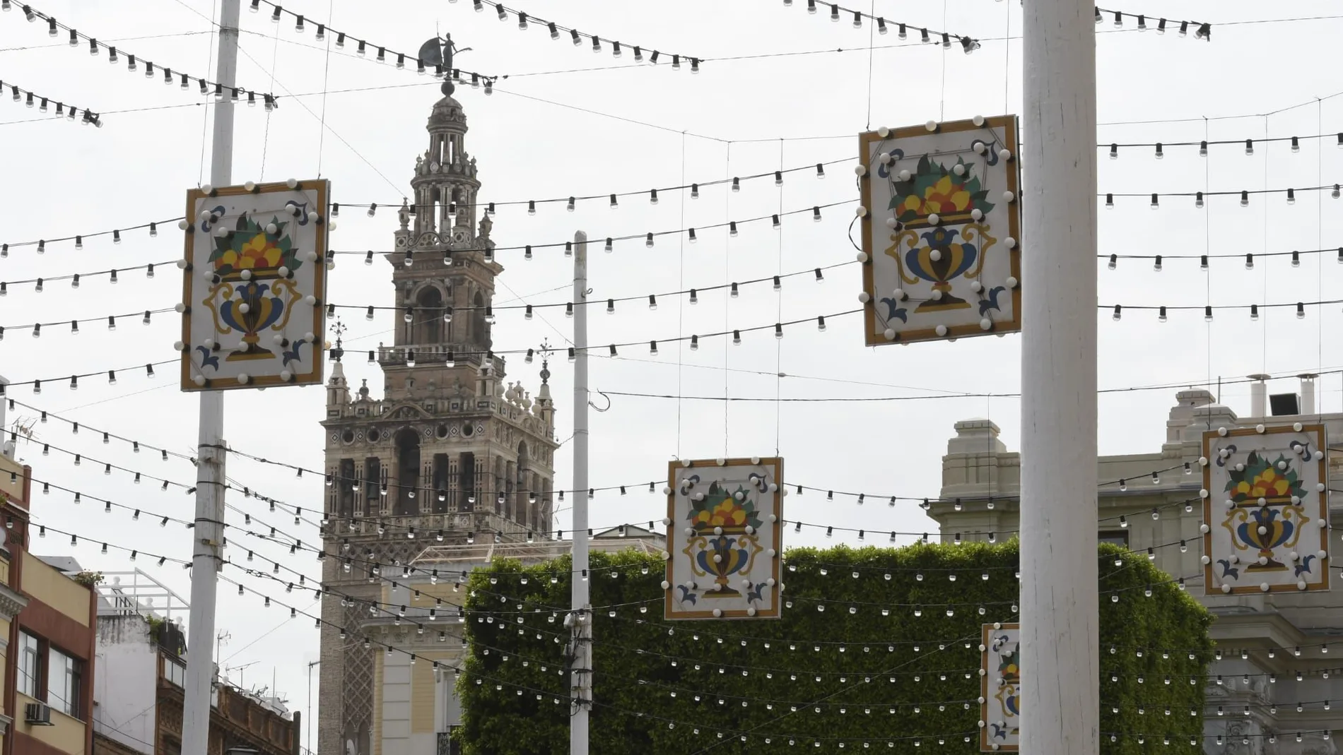 Vista de calles del centro de Sevilla, con la Giralda al fondo, engalanadas con adornos por la Feria de Abril