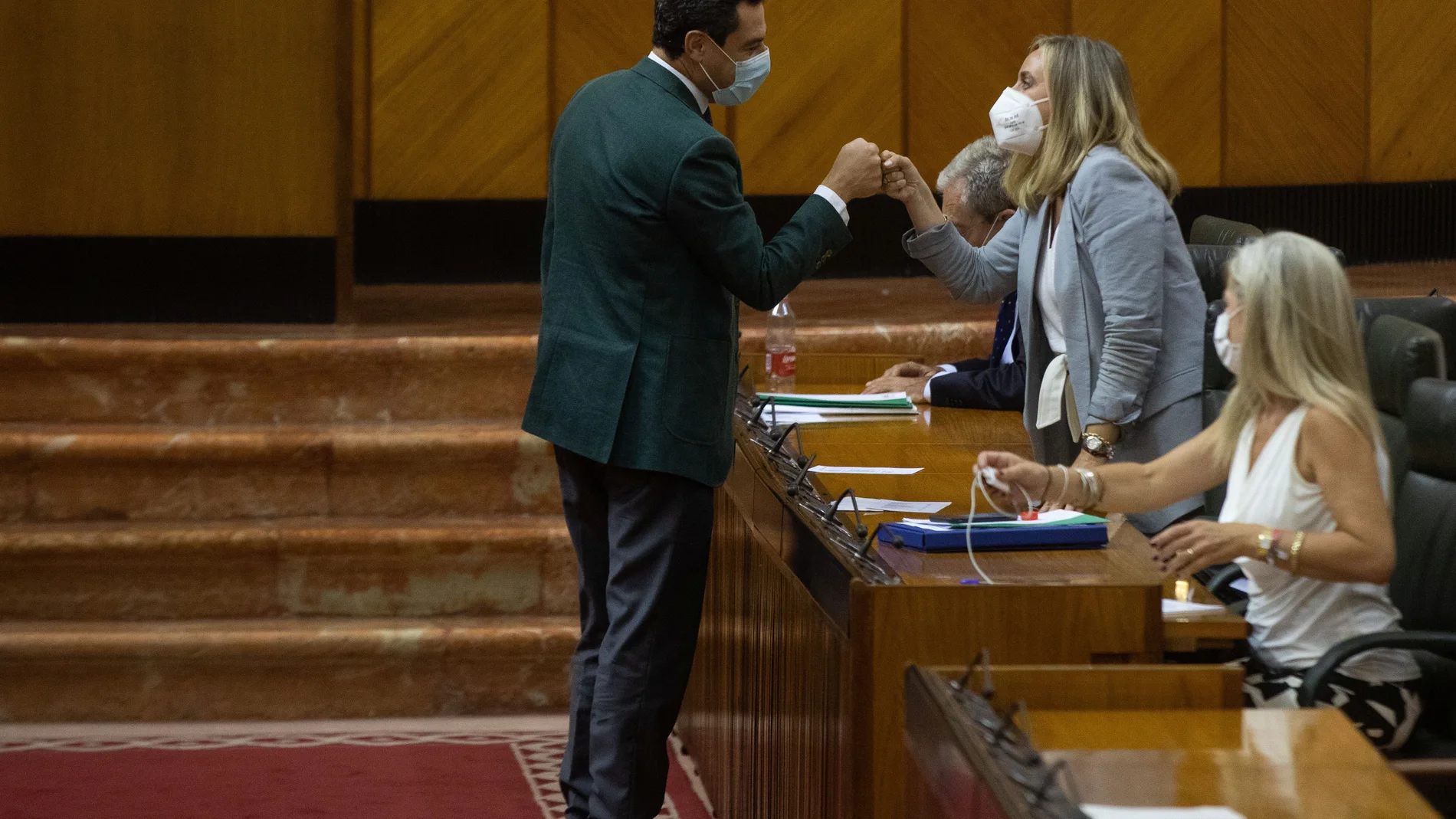 El presidente de la Junta de Andalucía, Juanma Moreno, felicita a la consejera de Fomento, Marifrán Carazo, tras la aprobación de la tramitación de la Lista