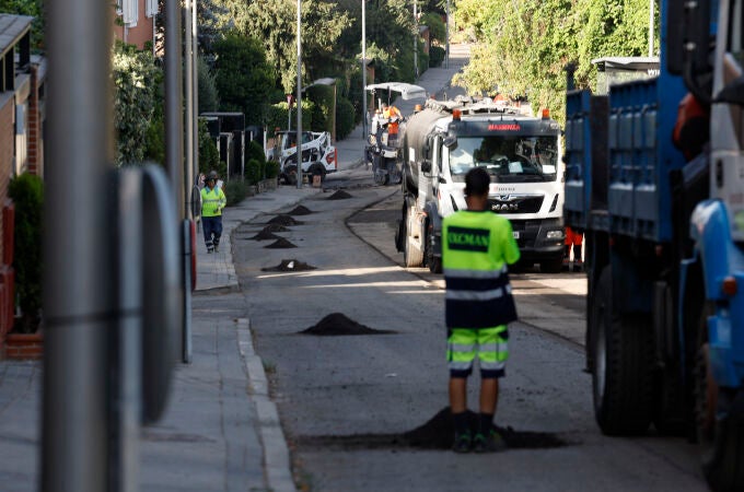 Varios operarios trabajan en el asfaltado de un distrito madrileño