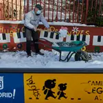 Un familiar colabora en la limpieza del hielo y la nieve en las inmediaciones del colegio Amadeo Vives tras la gran nevada por el paso de la borrasca &#39;Filomena&#39;, en Madrid