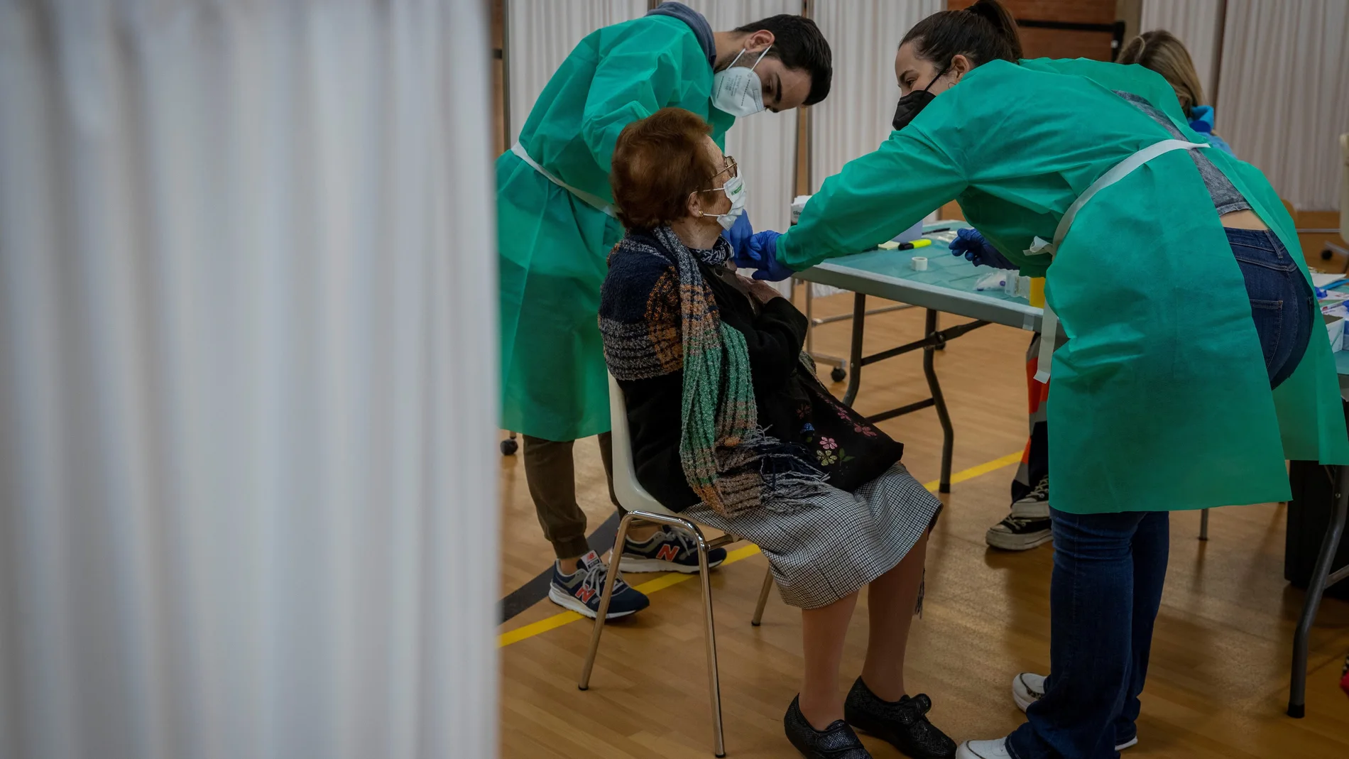 Personal sanitario del Servicio Andaluz de Salud (SAS) vacuna a una mujer contra la covid