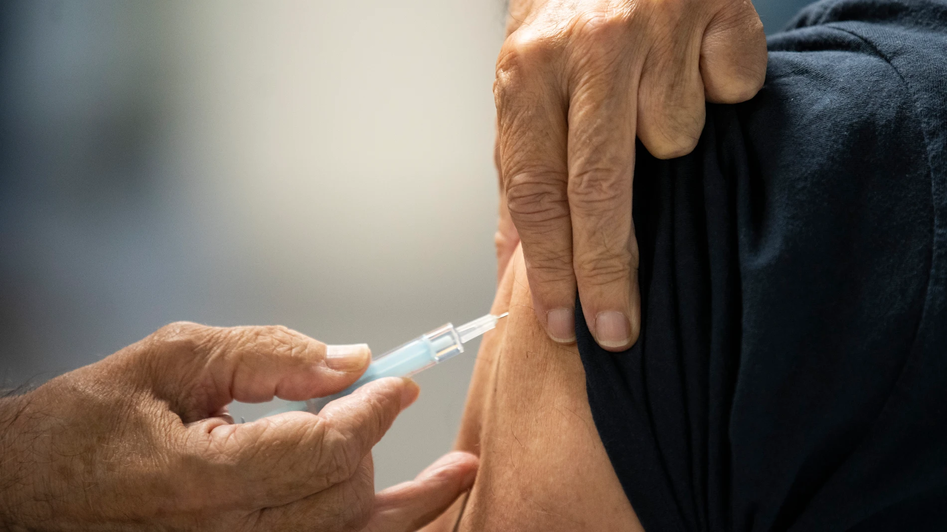 Un sanitario suministra una vacuna contra la covid