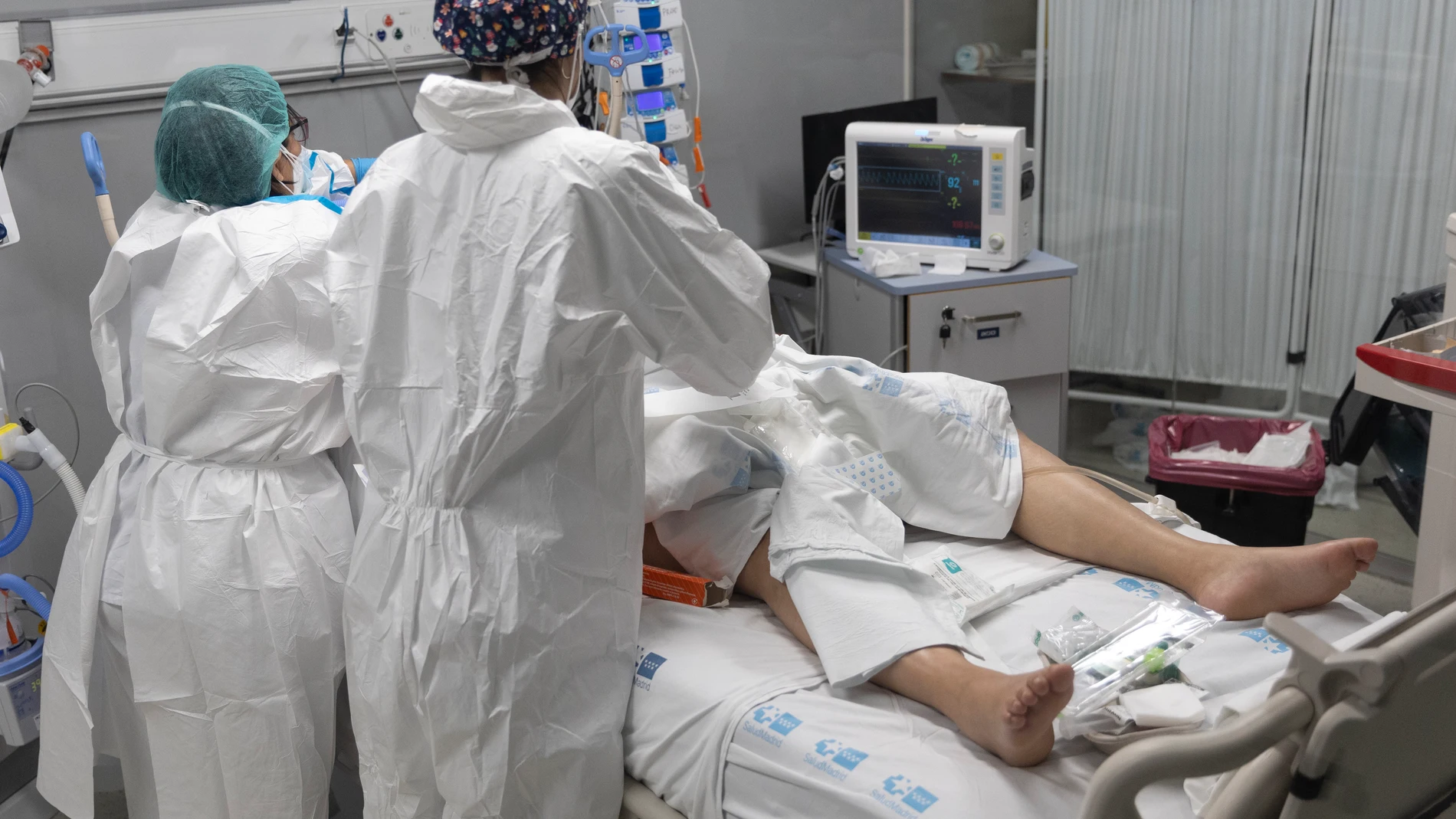 Dos sanitarios alrededor de un paciente ingresado en la UCI del Hospital Enfermera Isabel Zendal de Madrid