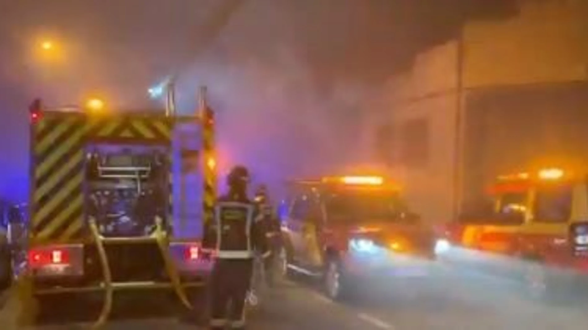 Bomberos de Madrid trabajan en la extinción de un incendio en una nave de artes gráficas en la calle Trole