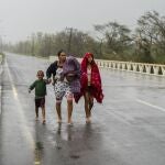 Una familia camina bajo la lluvia en busca de refugio después de que el huracán Ian inundara su casa en Pinar del Río