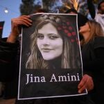 Una manifestante lleva un cartel de Masha Amini en una protesta contra la dictadura iraní en Melbourne, Australia