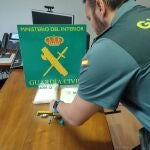 Agente de la Guardia Civil junto a la droga incautada. GUARDIA CIVIL