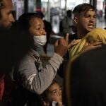 Migrantes venezolanos discuten sus planes mientras esperan un autobús que los lleve al norte en la Estación de Autobuses del Norte en la Ciudad de México