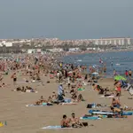 La subida de las temperaturas podría hacer que se repitan estas imágenes durante el puente del 1 de Noviembre. En la imagen, decenas de personas se bañan y toman el sol en la playa de la Malvarrosa de Valencia.