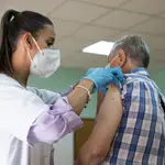 Una enfermera vacuna a un hombre contra la gripe y el Covid. María José López / Europa Press