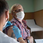 Una enfermera vacuna a un hombre contra la gripe y el Covid en Sevilla