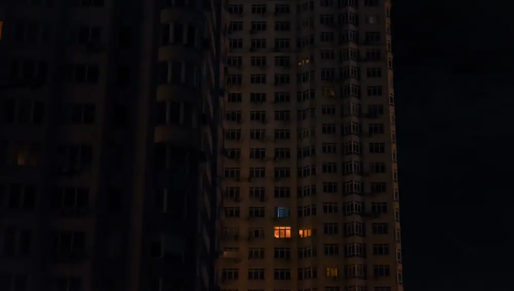 Un solo apartamento con luz en un edificio residencial a oscuras en el centro de la capital ucraniana