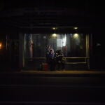 Dos ucranianos sentados en la parada de autobús en la oscuridad este 22 de octubre en Kyiv
