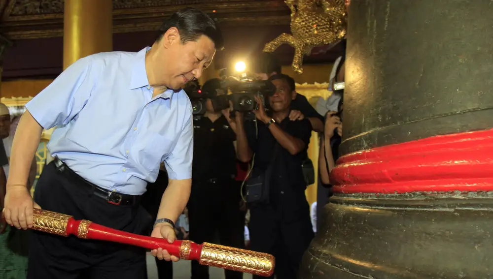 vicepresidente chino Xi Jinping golpea una campana gigante durante su visita a la pagoda de Shwedagon en Yangon, Myanmar, el 19 de diciembre de 2009