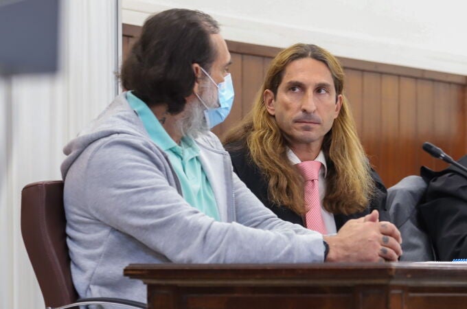 El acusado de decapitar a un amigo en octubre de 2020, M.J.M.B. (i), acompañado de su abogado, durante el juicio que ha comenzado hoy en la Audiencia Provincial de Huelva. EFE/Julián Pérez
