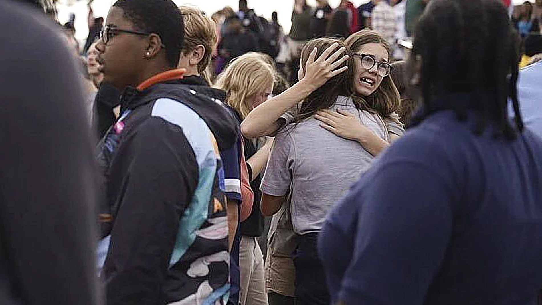 Estudiantes se abrazan tras escapar del tiroteo en el instituto de secundaria en St. Louis, este lunes 24 de octubre