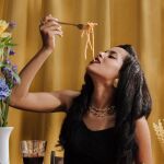 Mujer comiendo y celebrando el día de la pasta