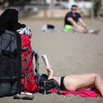 Una turista disfruta del buen clima en la playa de la Malagueta en Málaga capital, este martes