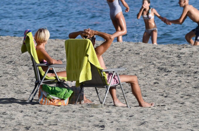 Unas personas disfrutan del buen tiempo en la playa de Aguadulce en Roquetas de Mar (Almería)
