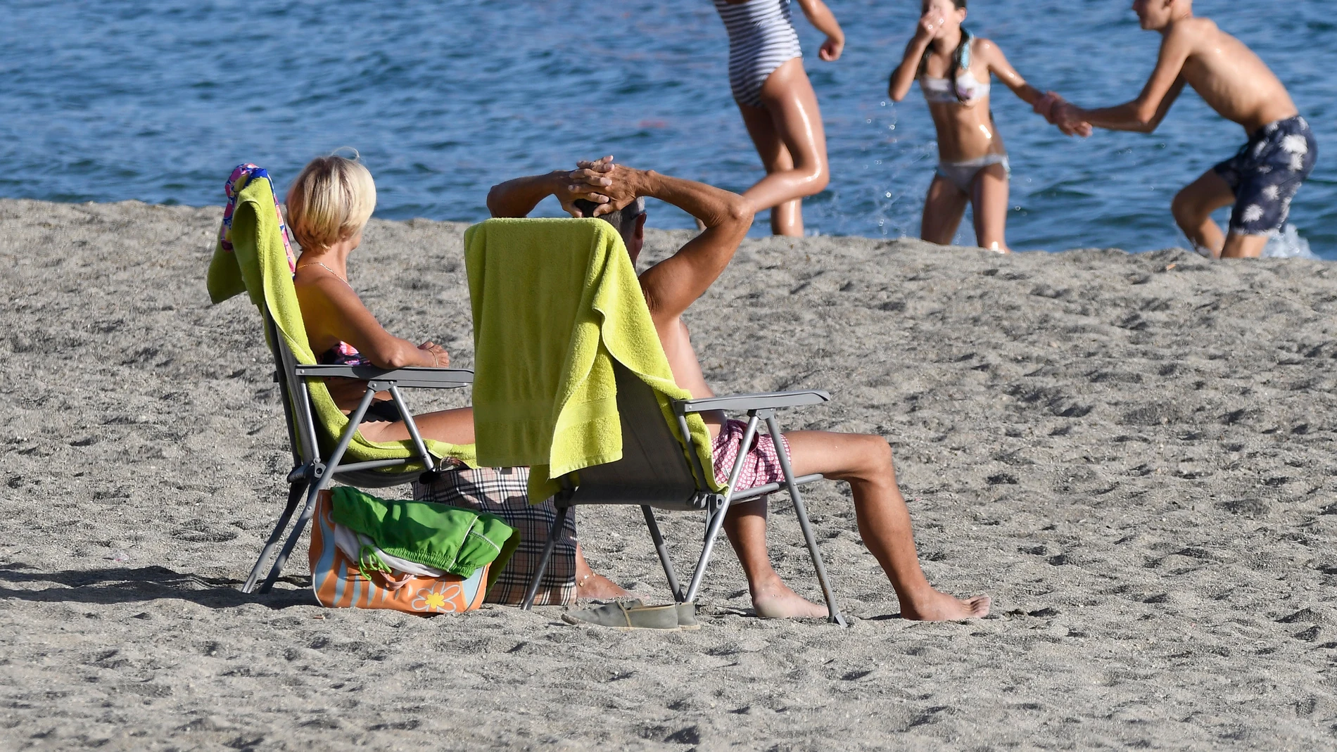 Unas personas disfrutan del buen tiempo en la playa de Aguadulce en Roquetas de Mar (Almería), este jueves.