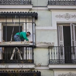 Un trabajador autonomo repara el balcón de una vivienda en Madrid