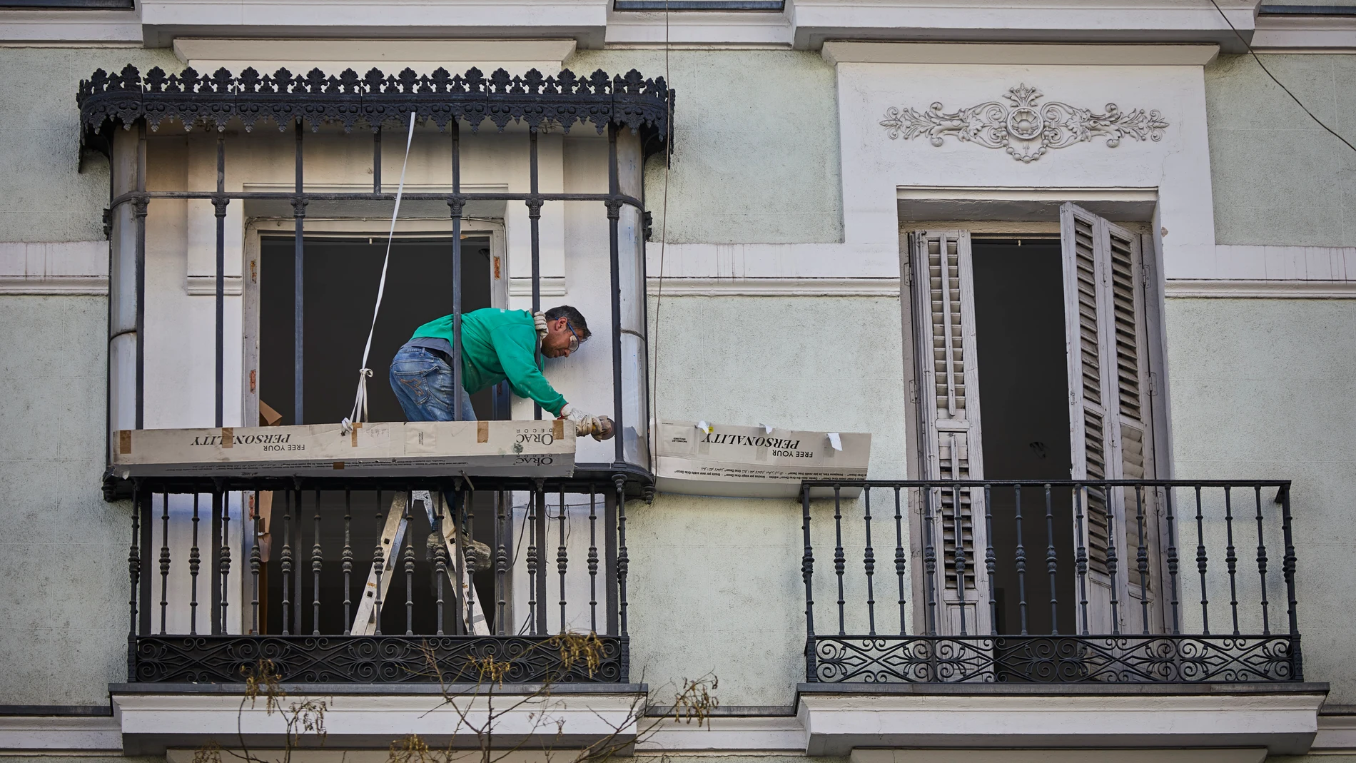 Un trabajador autonomo repara el balcón de una vivienda en Madrid