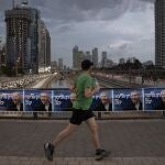 Un hombre corre junto a carteles electorales del líder del Likud, Benjamin Netanyahu