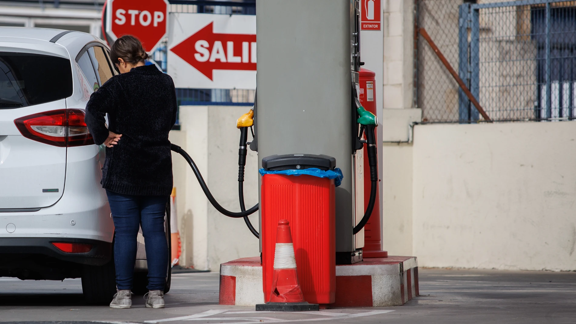 Un mujer reposta carburante en una gasolinera, a 28 de octubre de 2022, en Madrid