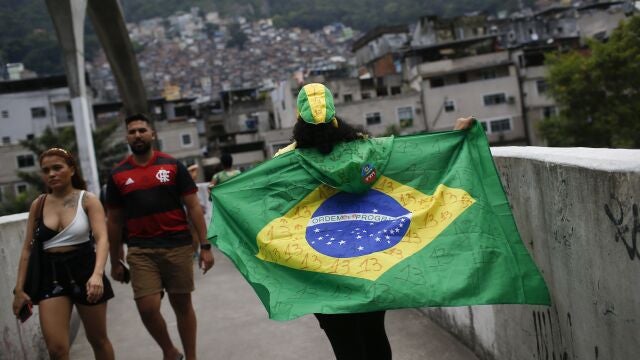 Una mujer camina sosteniendo una bandera brasileña con el número 13 del candidato presidencial Luiz Inacio Lula da Silva escrito en ella, en la favela da Rocinha durante la segunda vuelta de las elecciones presidenciales en Río de Janeiro,
