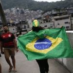 Una mujer camina sosteniendo una bandera brasileña con el número 13 del candidato presidencial Luiz Inacio Lula da Silva escrito en ella, en la favela da Rocinha durante la segunda vuelta de las elecciones presidenciales en Río de Janeiro,