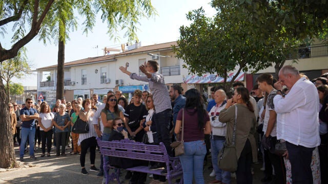 Un familiar de la víctima, subido en un banco, realiza una protesta durante el minuto de silencio para recordar al joven de 18 años