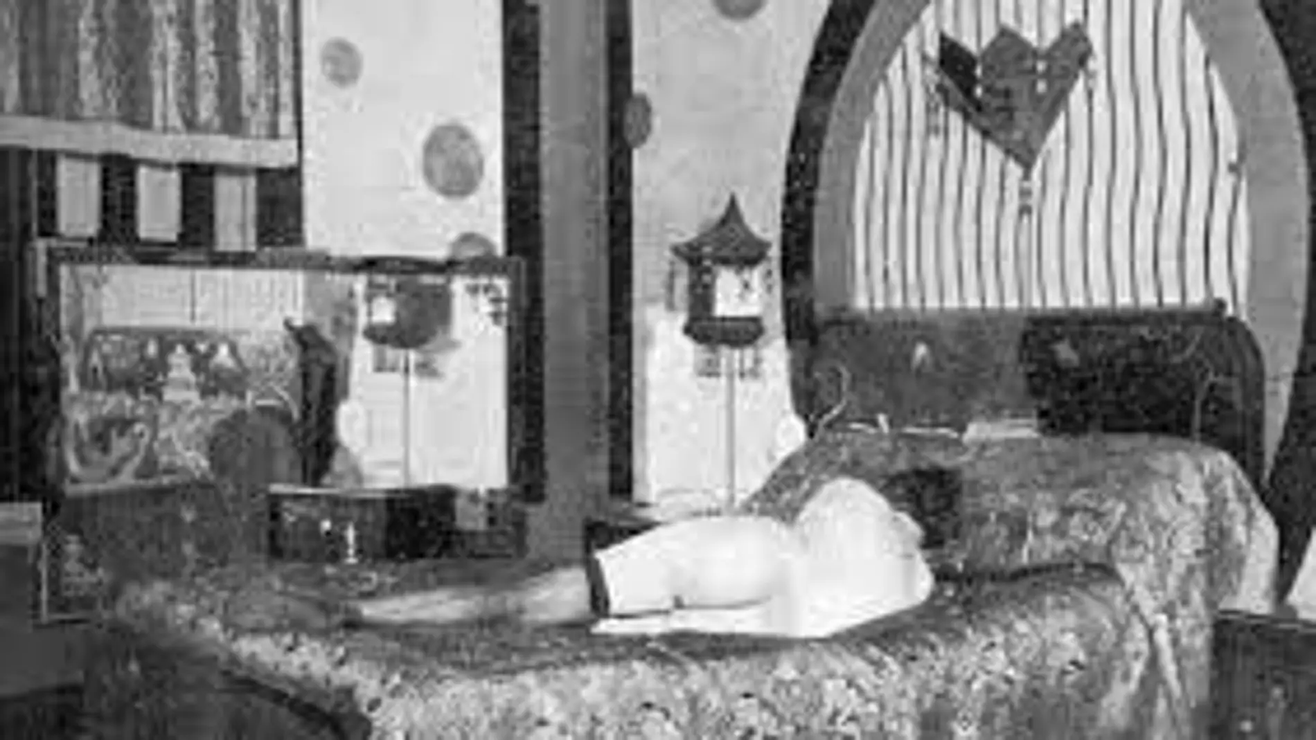 Una prostituta, tumbada en una cama del burdel