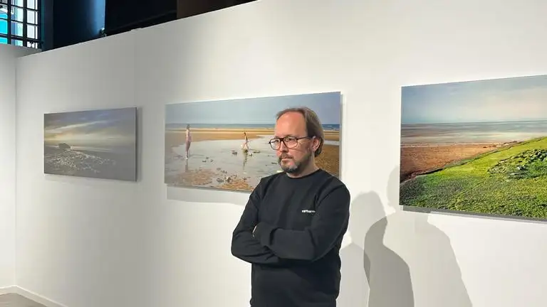 Eduardo Nave, junto a sus fotografías tomadas en Normandía que forman parte de la muestra
