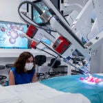 La presidenta de la Comunidad de Madrid, Isabel Díaz Ayuso, observa como un robot manipula uvas de muestra en una de las salas del nuevo Centro Quirúrgico del Hospital público Gregorio Marañón