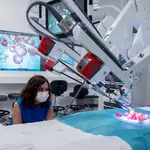 La presidenta de la Comunidad de Madrid, Isabel Díaz Ayuso, observa como un robot manipula uvas de muestra en una de las salas del nuevo Centro Quirúrgico del Hospital público Gregorio Marañón