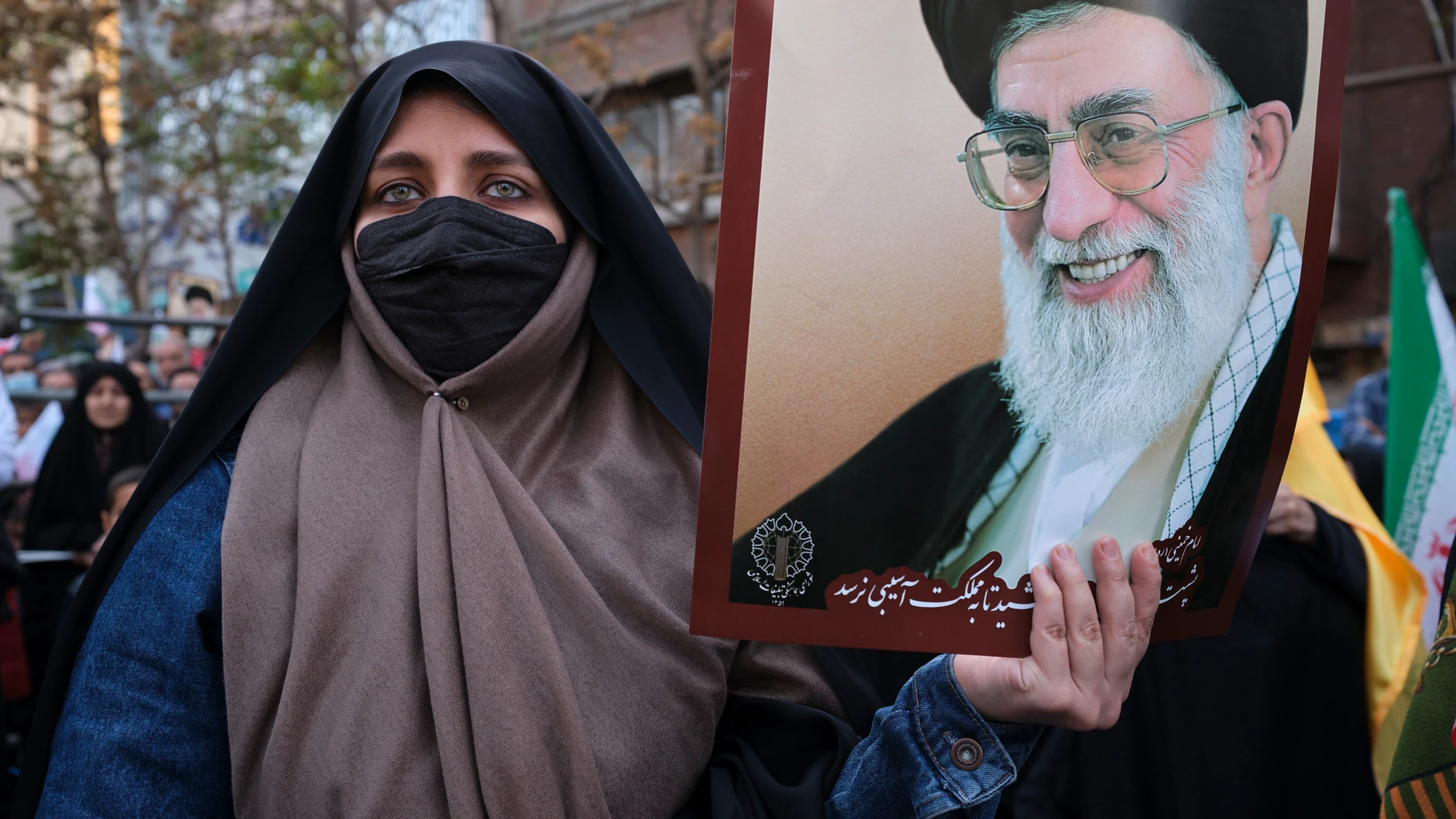 Una mujer muestra una imagen del líder supremo de Irán, Ali Jameneí, durante una manifestación en Teherán