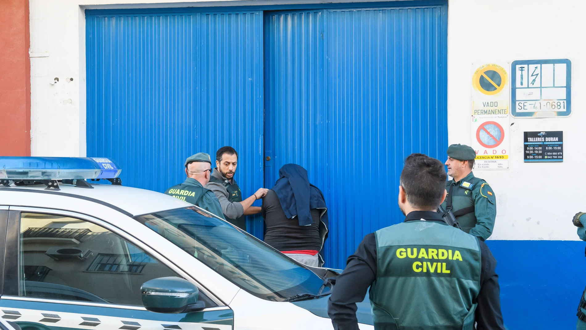Agentes de la Guardia Civil durante un registro realizado en un taller mecánico en Tomares (Sevilla) este viernes en el marco de una operación contra el tráfico de cocaína a gran escala, en la que han participado unos 200 agentes desplegados en Madrid, Ciudad Real y las provincias andaluzas de Cádiz y Sevilla
